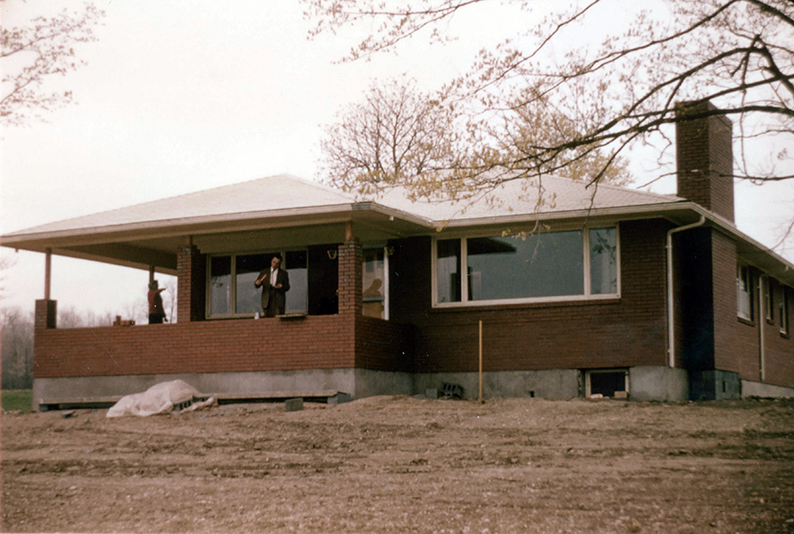 Konstantin standing on the front porch of his house.