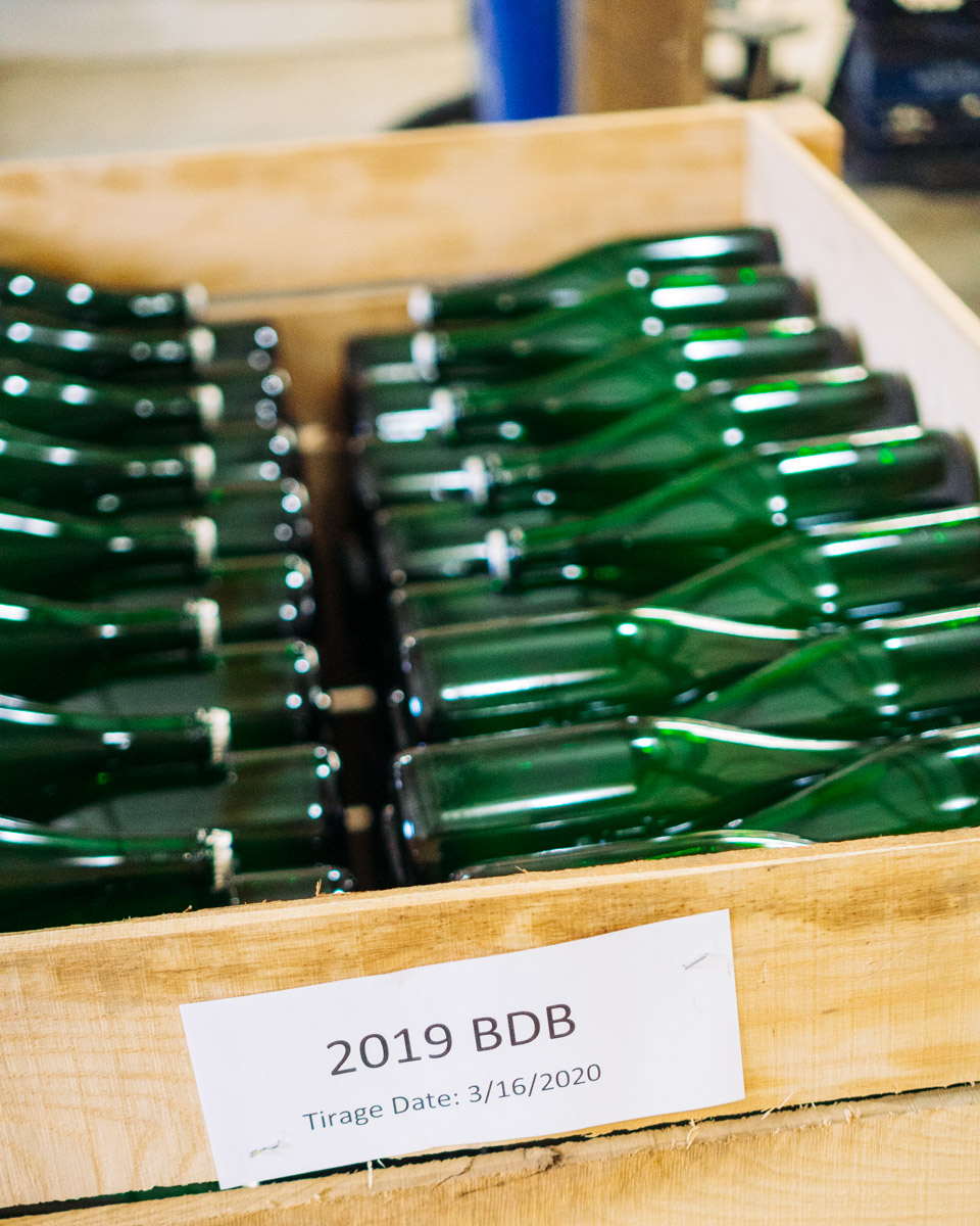 Bottles of Blanc de Blanc in wooden bins.