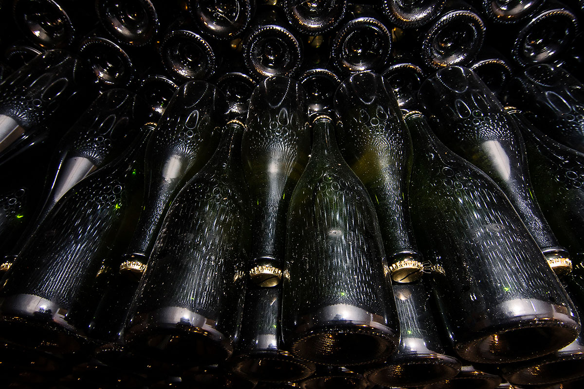 Several fermenting bottles of wines stacked together.