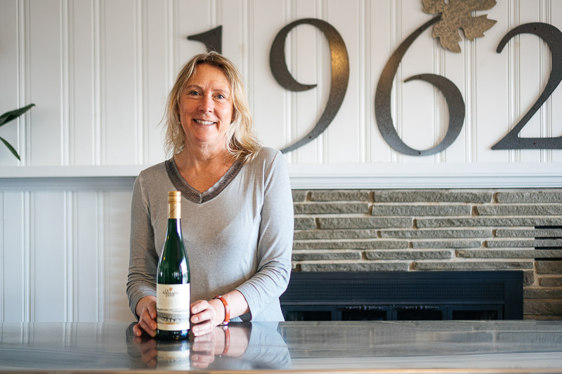 Yvonne Locke posing with a bottle of wine.