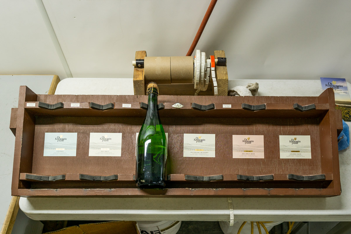 A bottle sitting on a wooden stand.