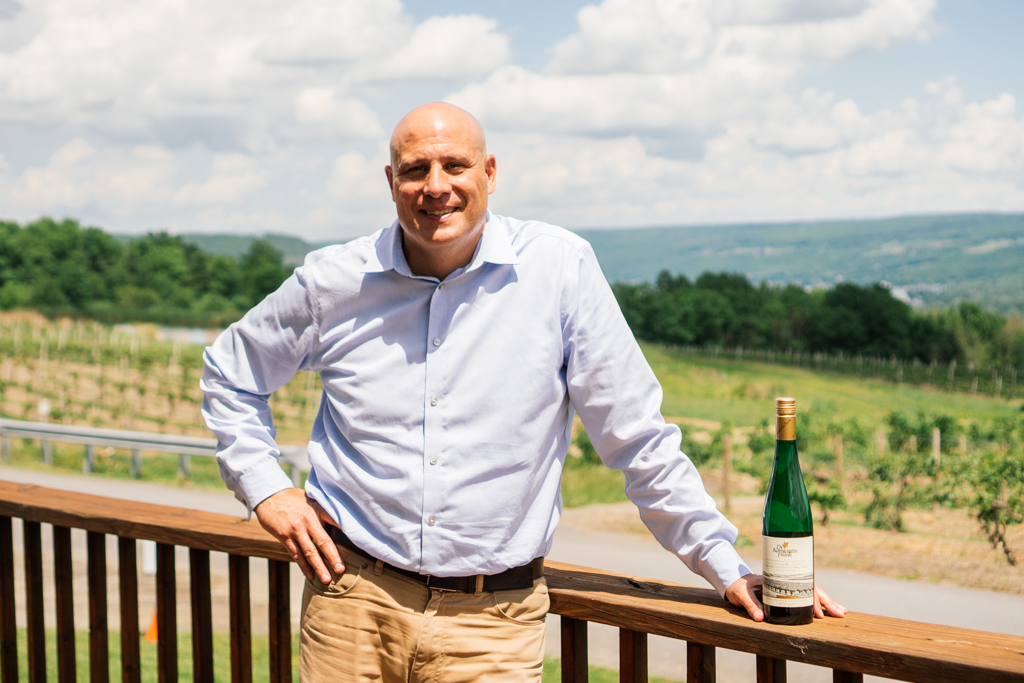 Eric Baist posing with a bottle of wine.