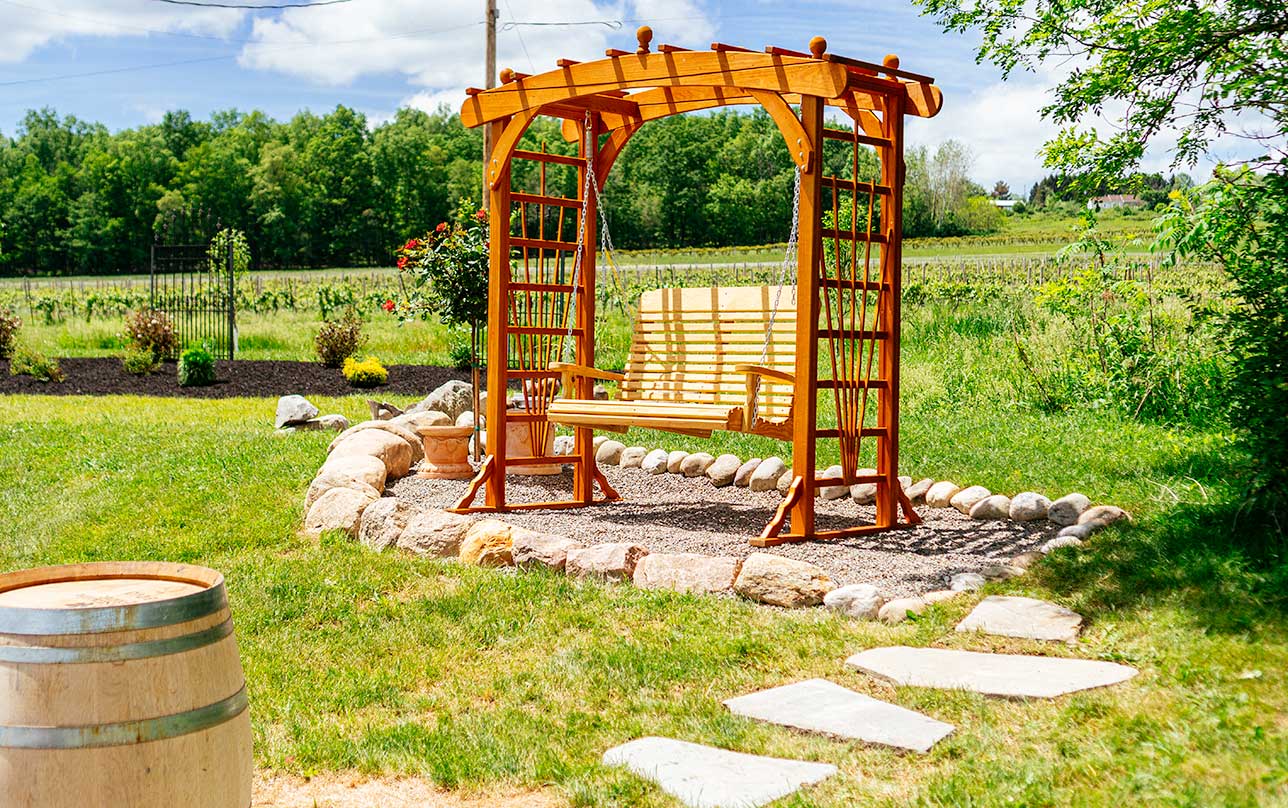 A wooden swing sitting in Eugenia's Garden.