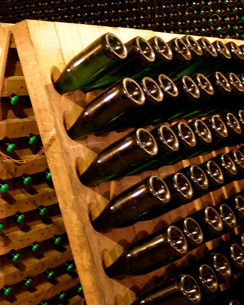 Bottles of sparkling wine in a riddling rack.