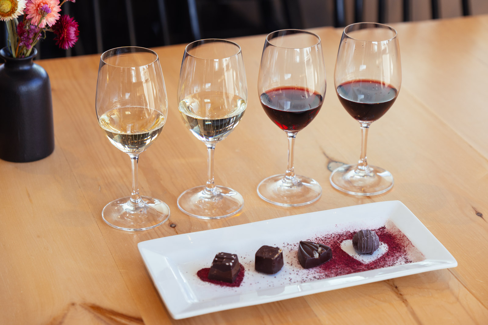 Four glasses of wine paired with 4 bites of chocolate